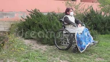 残疾<strong>妇女</strong>独自坐在轮椅上，戴着<strong>保护</strong>面具，在花园里向右看，但被隔离